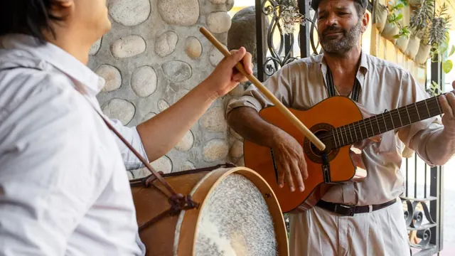 Two musicians playing a guitar and a drum